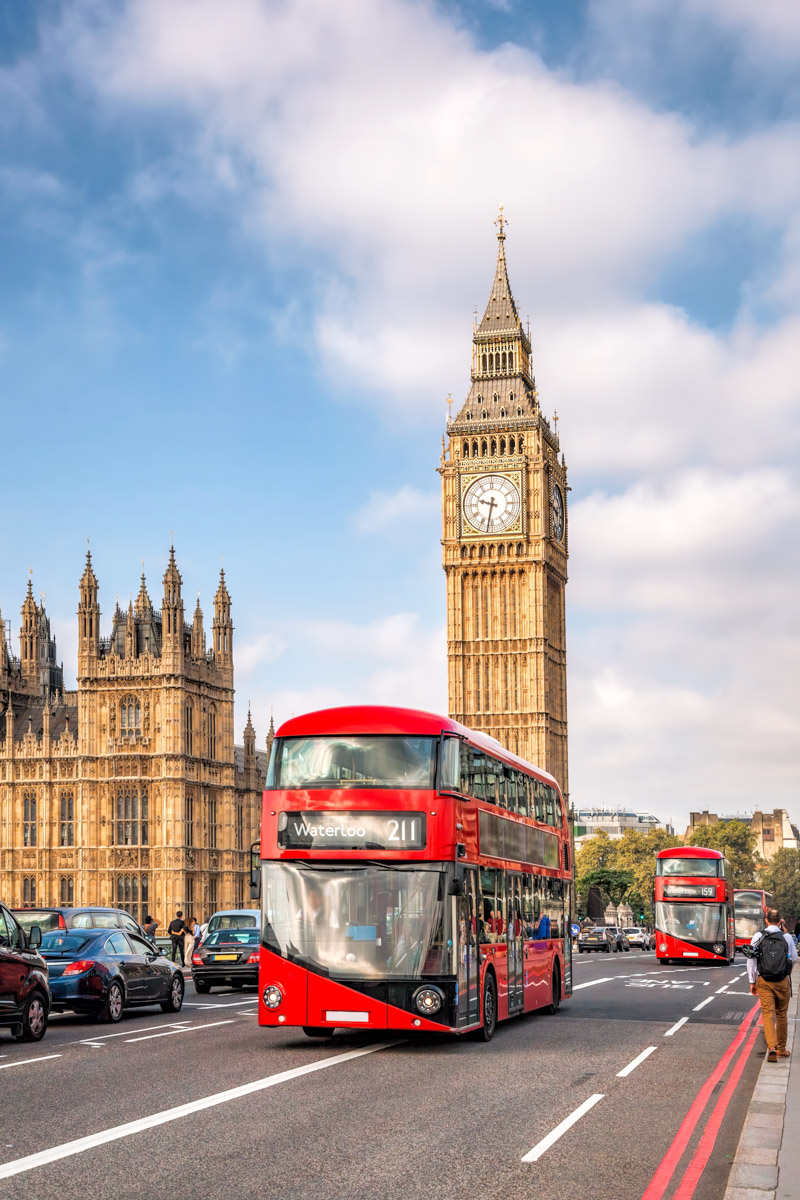 Big Ben with typical red buses on the bridge in London, England, UK